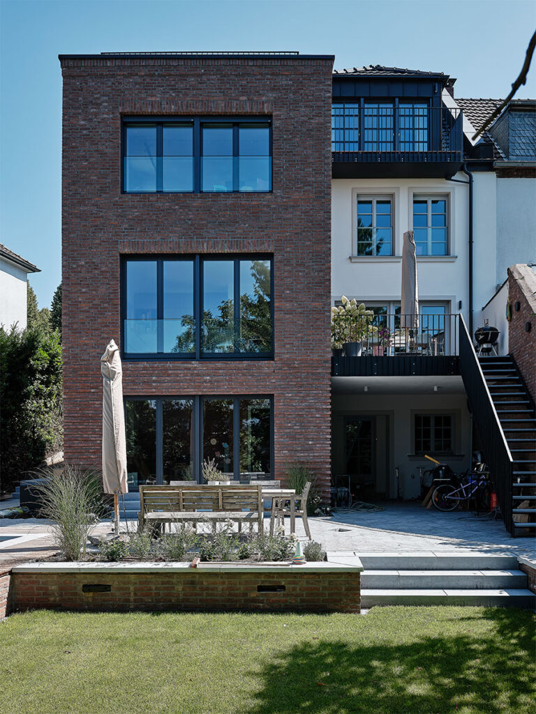 Außenansicht von einem sanierten Stadthaus mit neuen Anbau für eine Familie